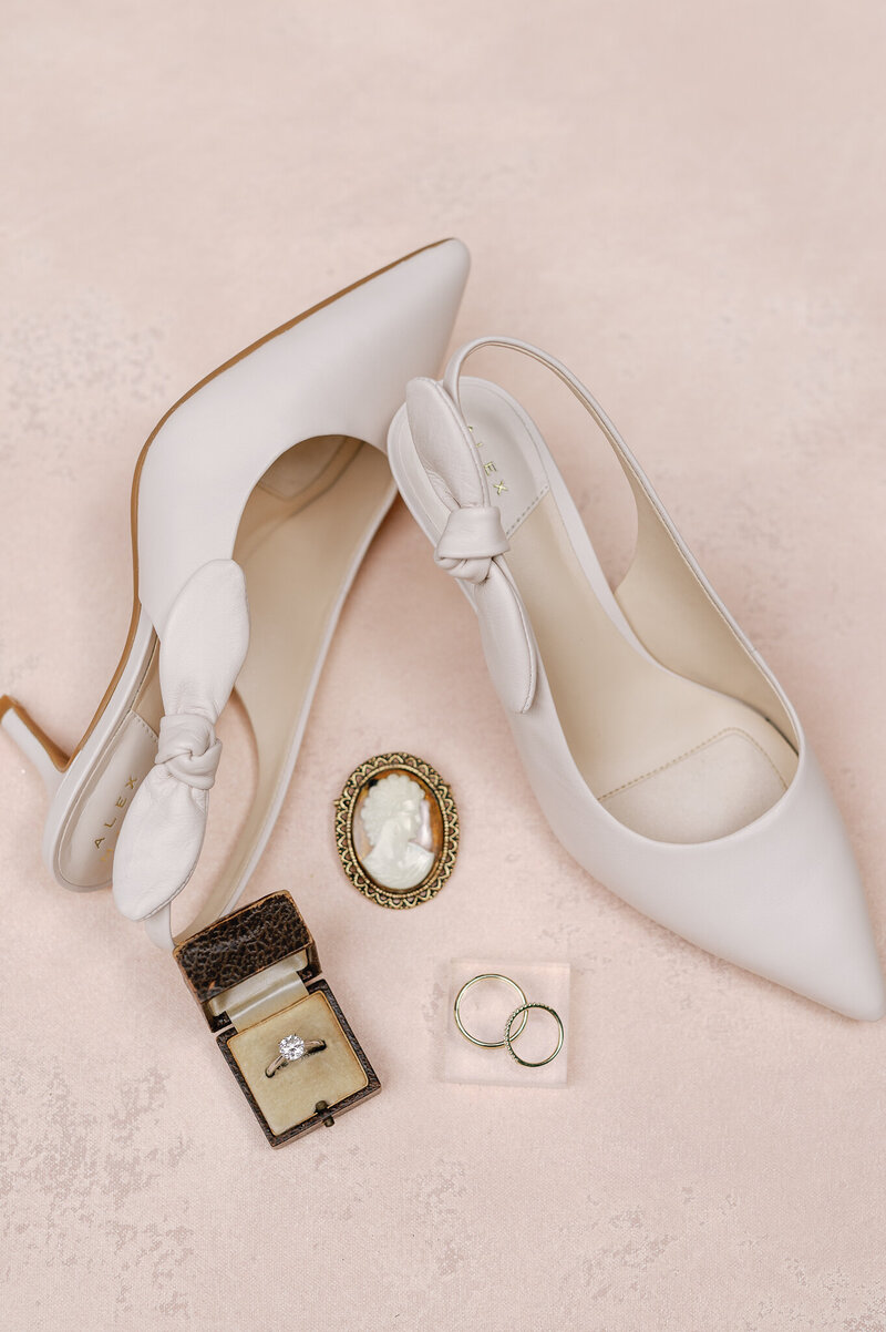 taupe shoes and wedding bands on a blush mat