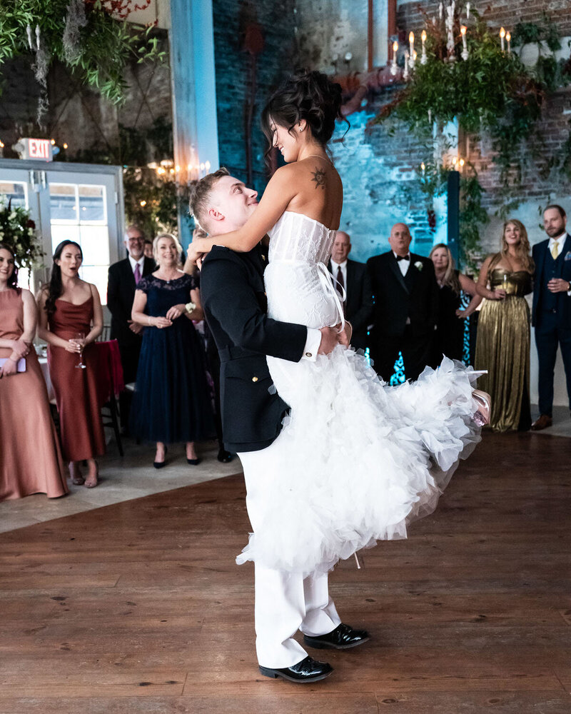 Groom lifts bride during first dance at Gallery Venue at Tomas Bistro wedding in New Orleans