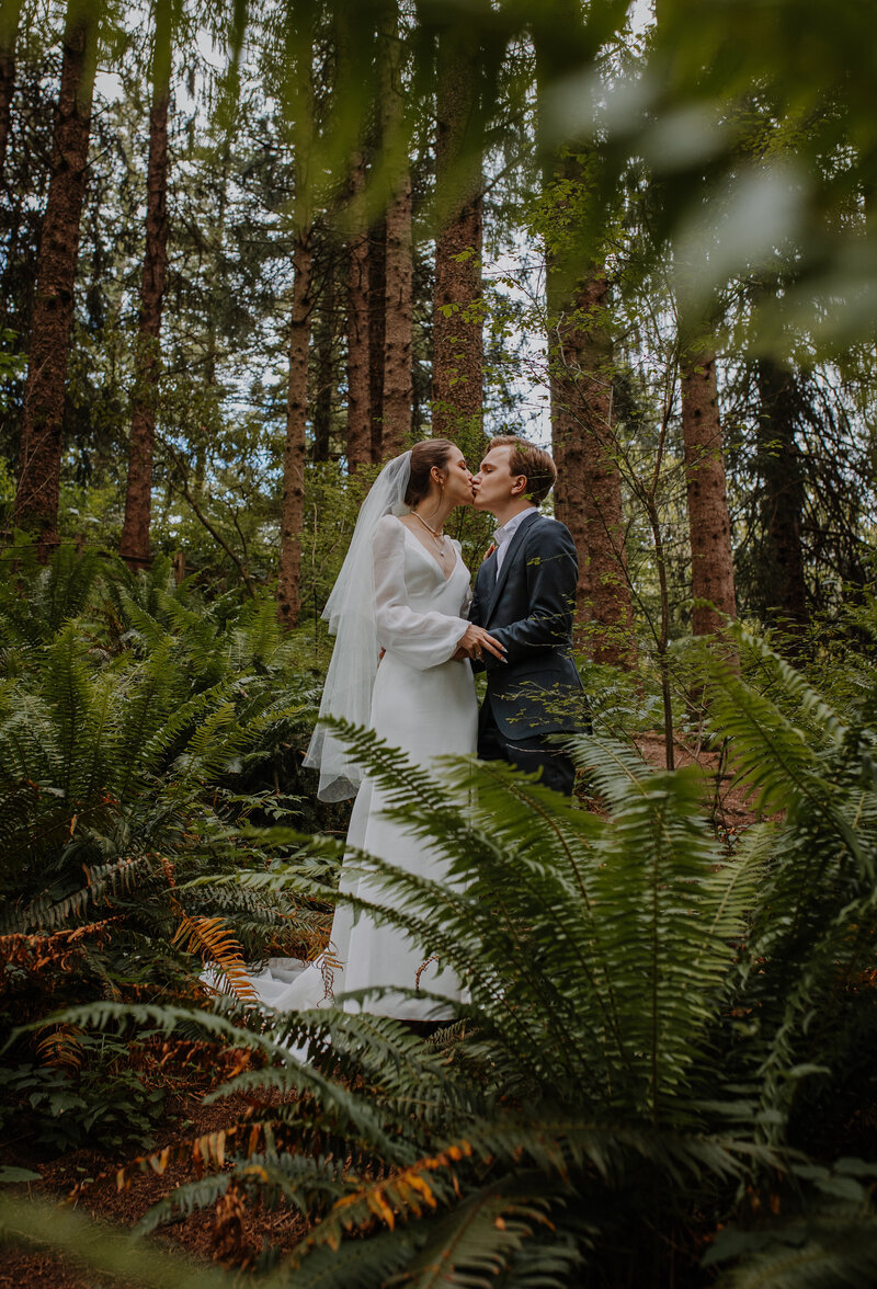 bride and groom kissing in a grassy area
