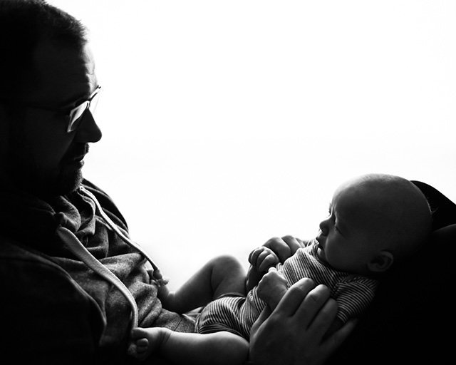 silhouette of father holding brand new baby on his lap | Meg Sivakumar Photography