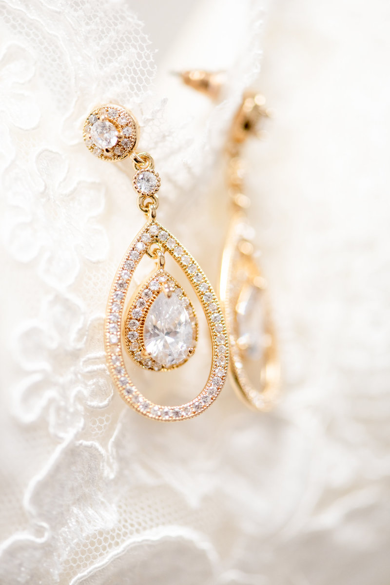 CLose up picture of crystal and yellow gold earrings.