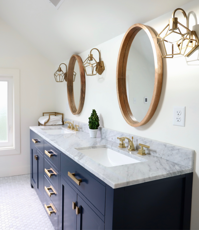 Blue vanity in bathroom with gold finishes