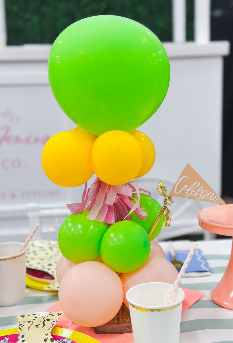 Small table balloon tower with yellow, green and pink balloons.