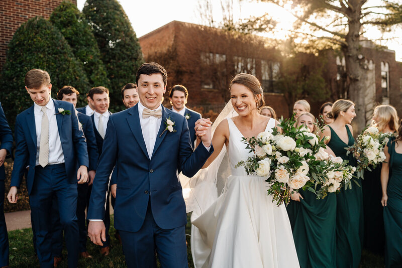 bride and groom walking with bridal party