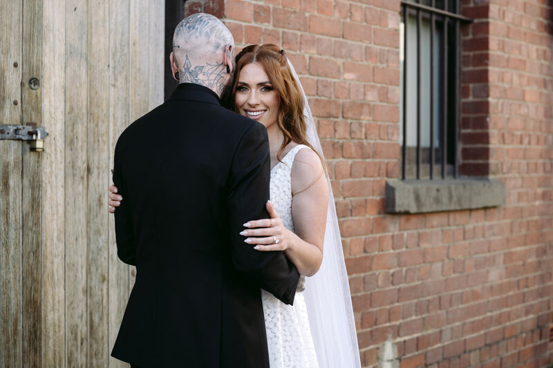 Bride and groom pose for a romantic portrait in a Melbourne laneway, captured by Carry Your Heart Photography. The urban backdrop adds charm to this timeless moment between the couple.