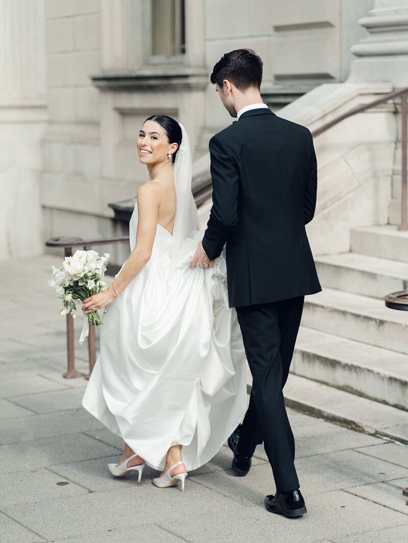 Couple walking in front of courthouse taken by baltimore wedding photographer, Nicole Simensky