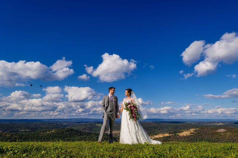 Couple holding hands at the overlook of Lehigh Valley during their Blue Mountain Resort wedding in the Poconos.