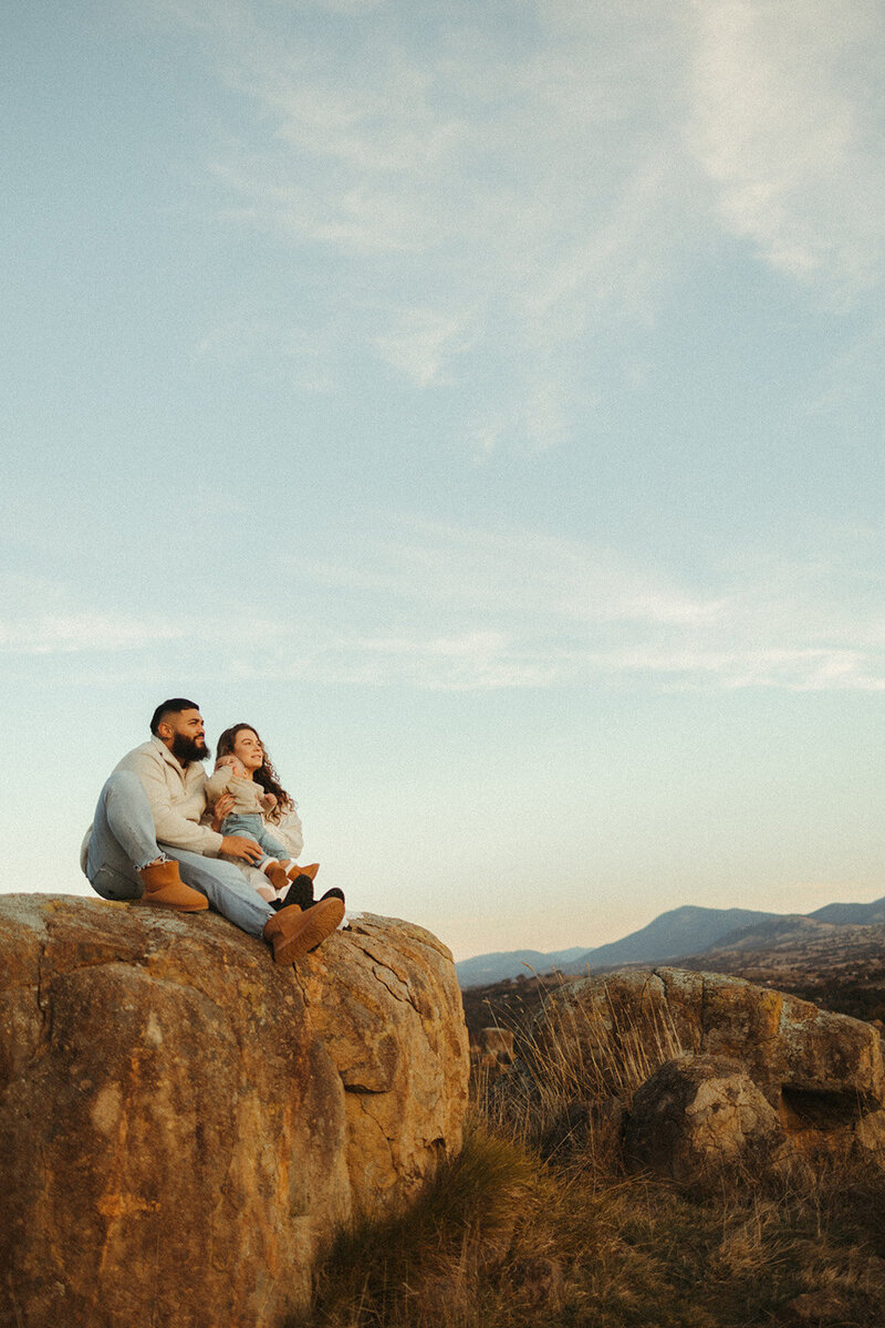Family holding baby with bushland background