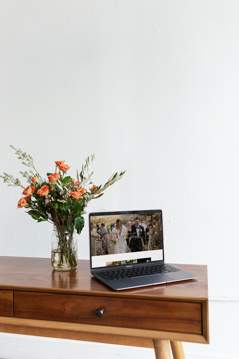 Website design and branding example by Coja Creative presented on a laptop next to a flower vase. 