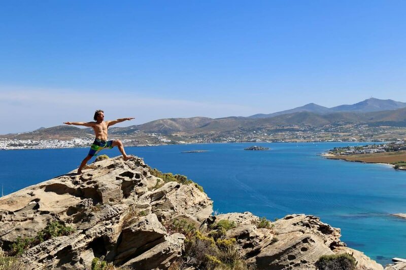 Strong warrior stance with dramatic coastline backdrop.