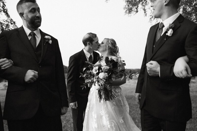 A couple standing together holding a bouquet of flowers after their wedding ceremony. 