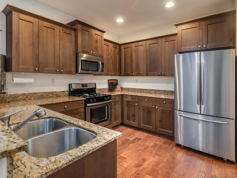 A kitchen featuring dark wooden cabinet and stainless steel appliances.
