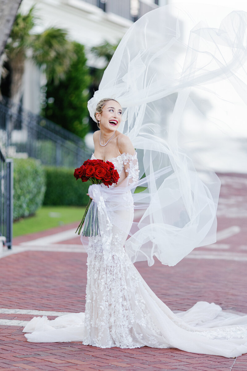 Stunning bride with flowing veil and red roses bouquet at The Breakers, captured by Claudia Amalia Photography, a wedding and lifestyle photographer based in Miami and Florida Keys South Florida, specializing in destination weddings.