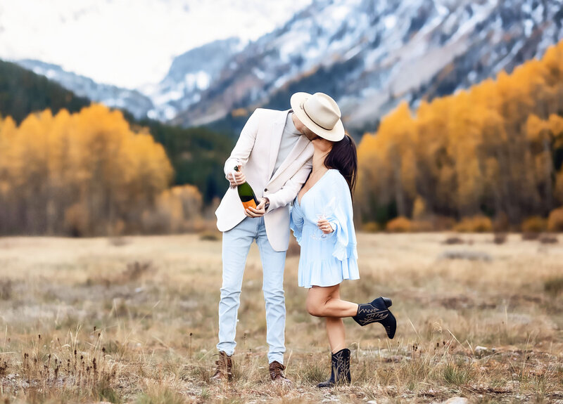 a couple kiss celebrating their engagement at pinecreek cookhouse in aspen colorado