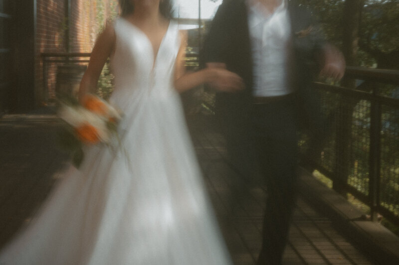 A blurry shot of a bride and groom walking hand-in-hand