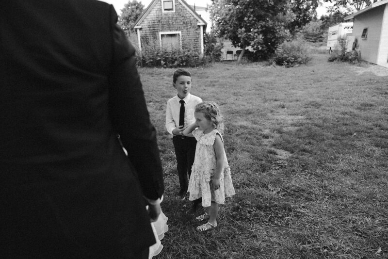 little boy sticking his tongue out at wedding reception with little girl black and white photography