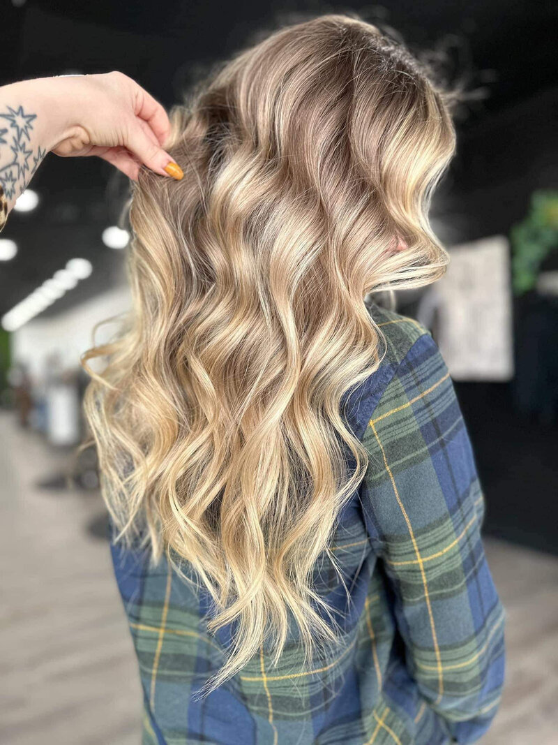 A curled blonde balayage in a salon