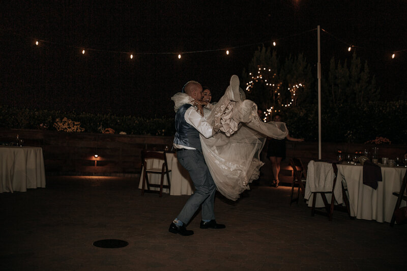groom spinning bride around in boho lace and tulle wedding dress