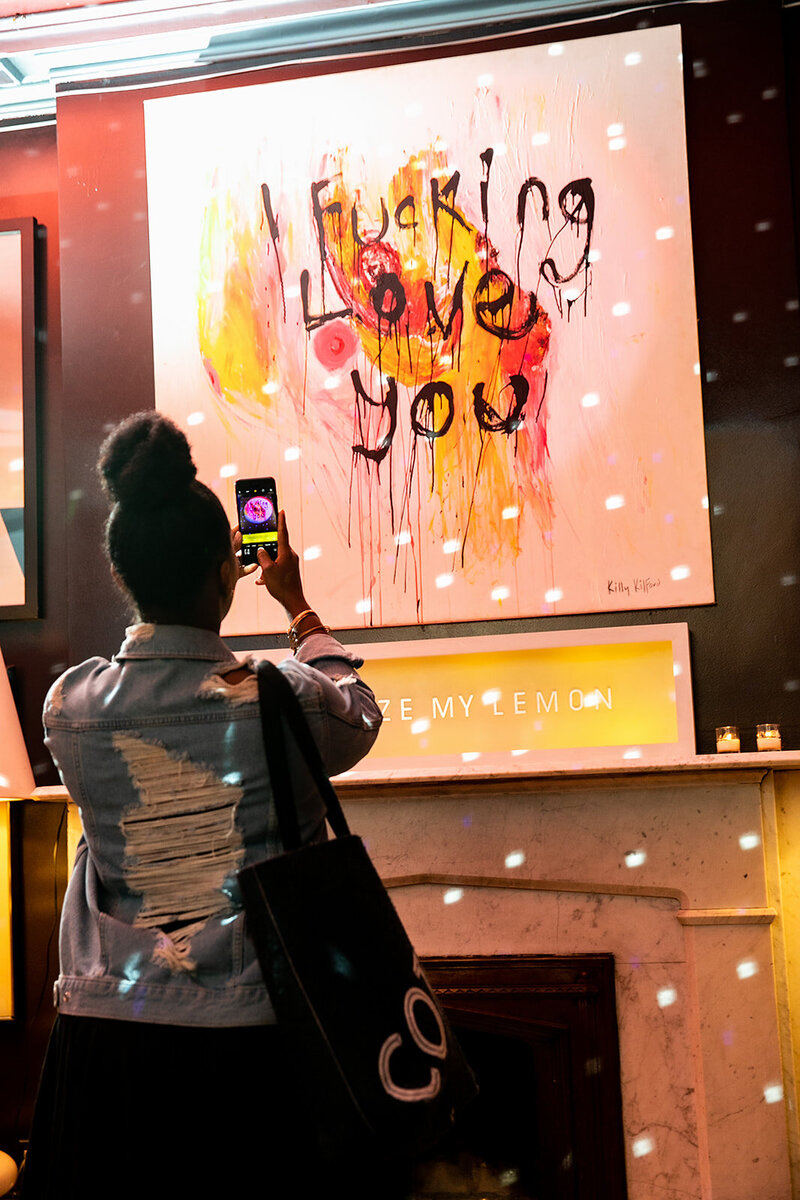 Image from the Kismet photoshoot in New York, featuring a person holding a phone capturing a photo of an art piece