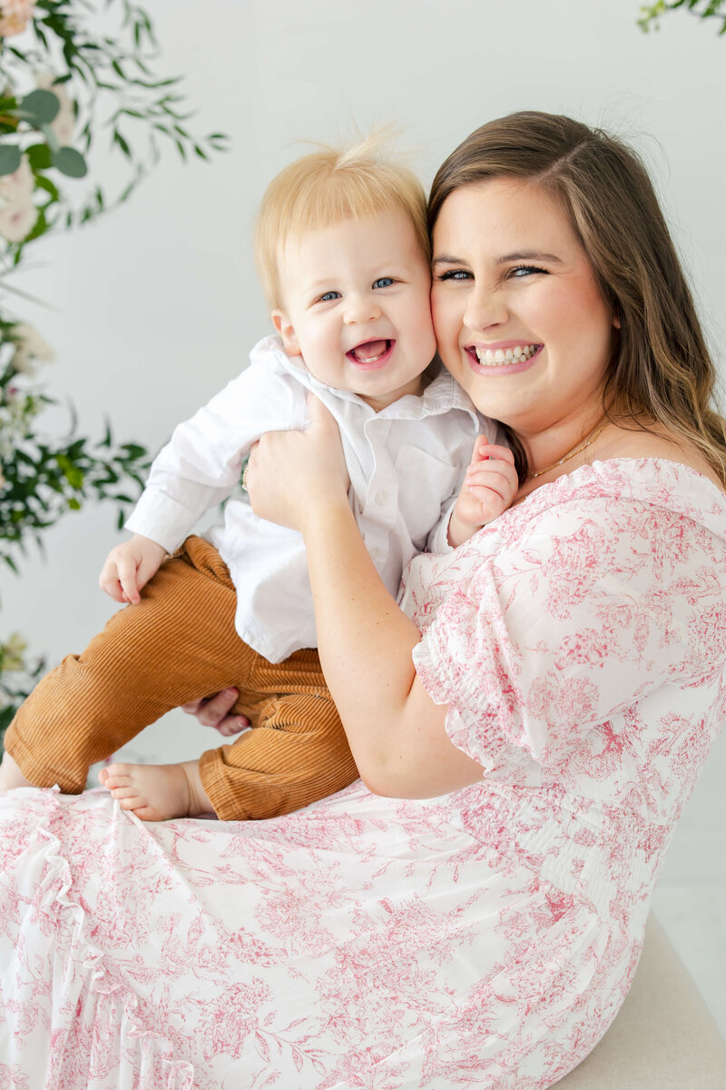 Mom holding son smiling at the camera for mini model rep program
