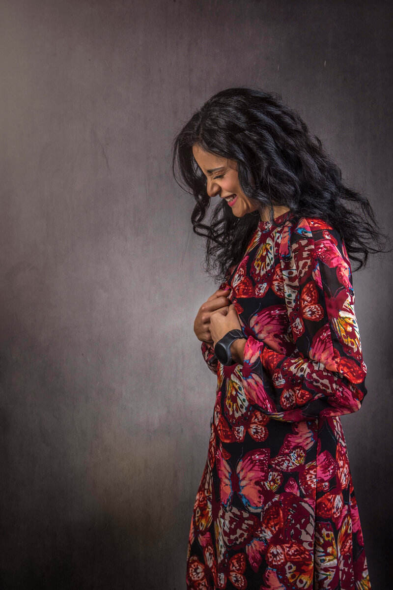 girl in floral dress laughs and looks down