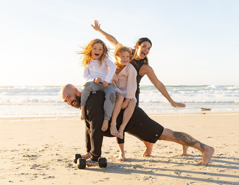 Jackie and Scott of Iron and Salt Fitness doing a beach family workout with their young kids.