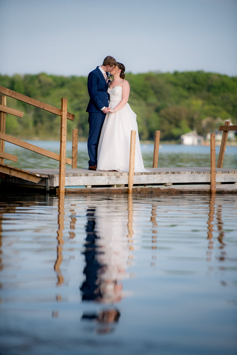Newlywed couple kissing on a dock in Puslinch, Ontario.