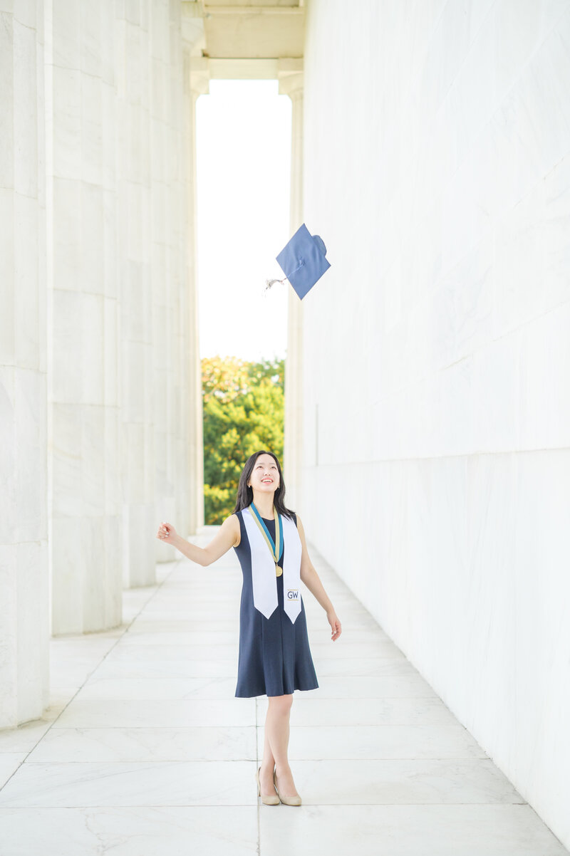 GWU Grad tosses caps in the columns at the Lincoln Memorial during her DC Grad session