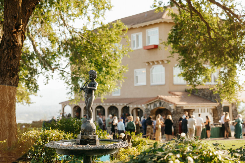 Bride and groom holding hands on a grand ballroom balcony beneath a crystal chandelier, photographed by a Washington wedding photographer.