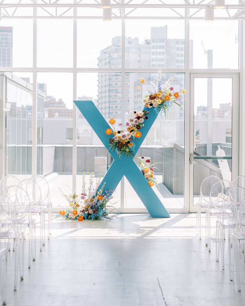 An installation of colourful modern flowers at a wedding ceremony overlooking downtown Montreal.