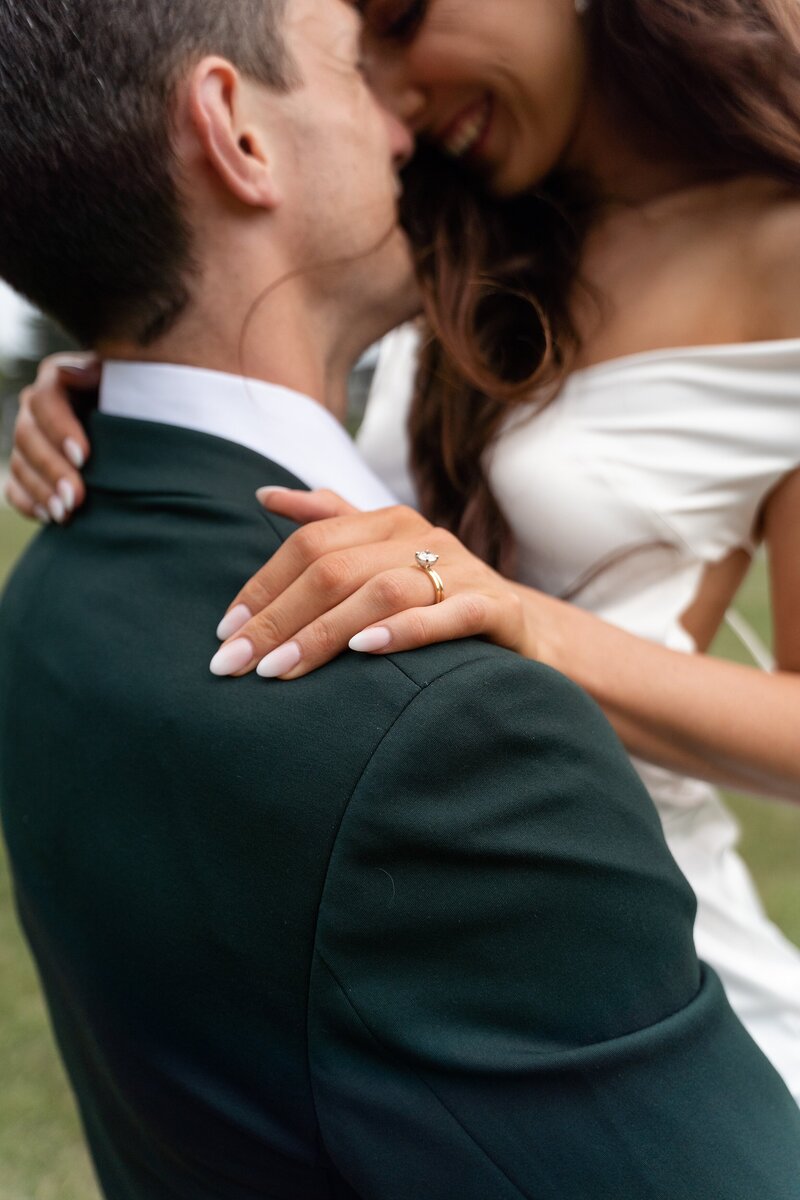 Groom picks up his beautiful new bride wearing an open back dress at Langdon hall in Cambridge Ontario