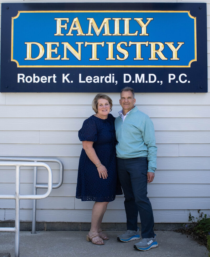Dr. Leardi and his wife, Sue Leardi, posing under the Leardi Family Dentistry office sign. 