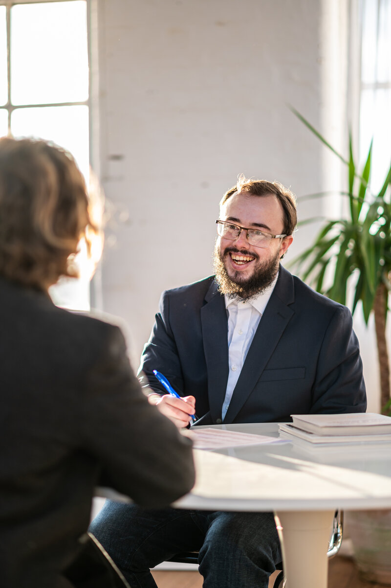 Portrait of Tom helping a new customer. 