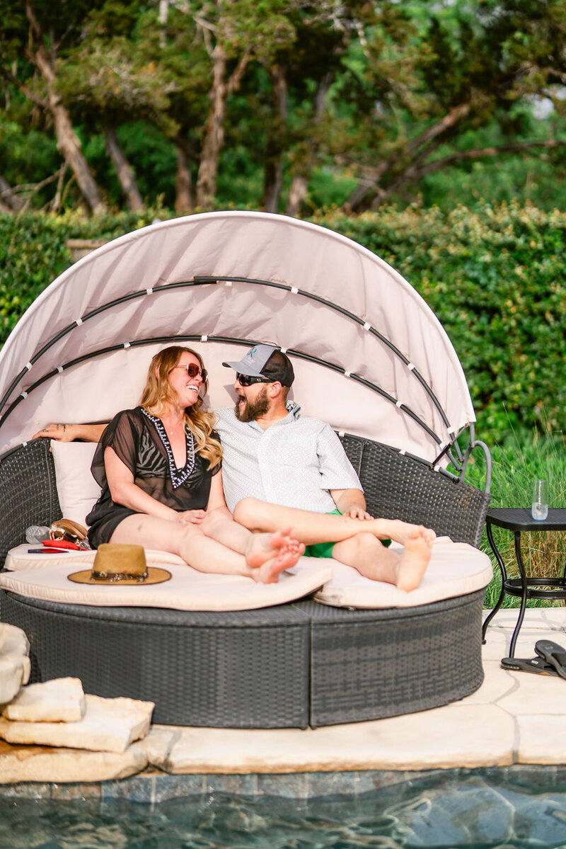 couple lounging near Pool area at Messina Inn in Wimberley Texas