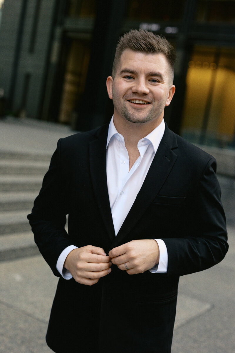 Toronto Wedding Photographer Smiling looking at the camera while wearing a suit