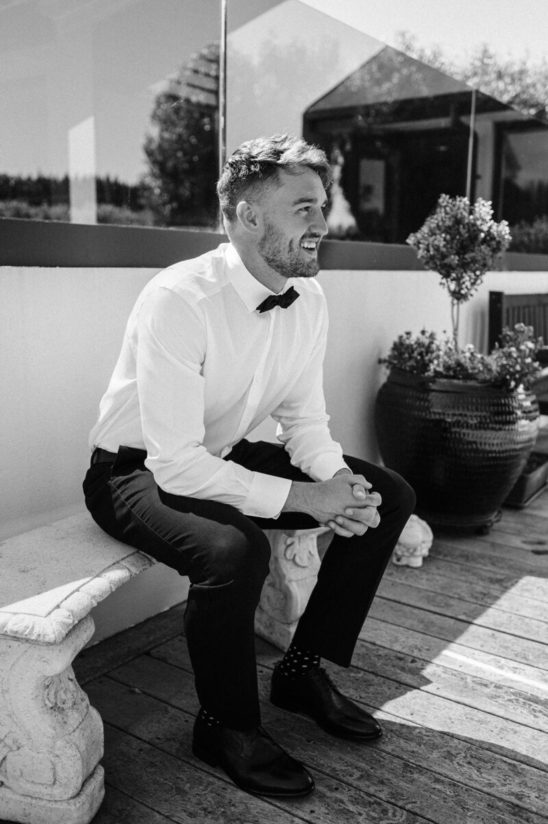 groom in white shirt with black pants and bowtie