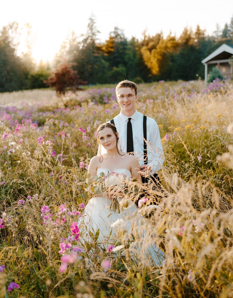a bride and groom standing in a field
