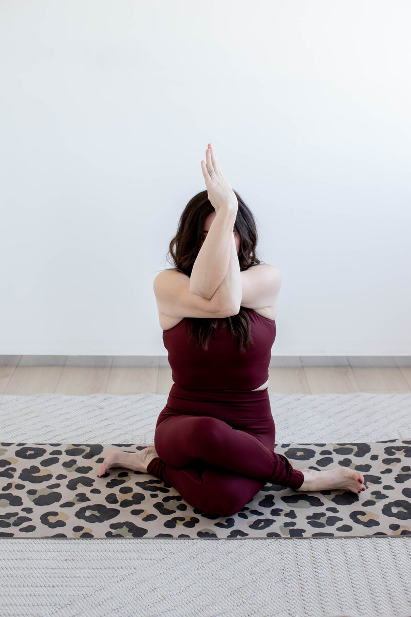 Woman in seated eagle yoga pose. 