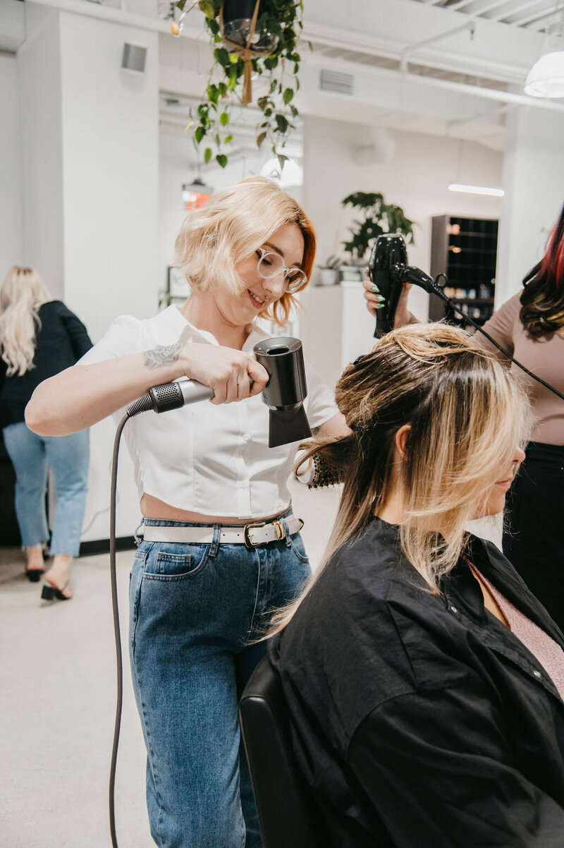 Salon Beau stylist expertly blow-drying a client’s hair for a polished, lived-in look