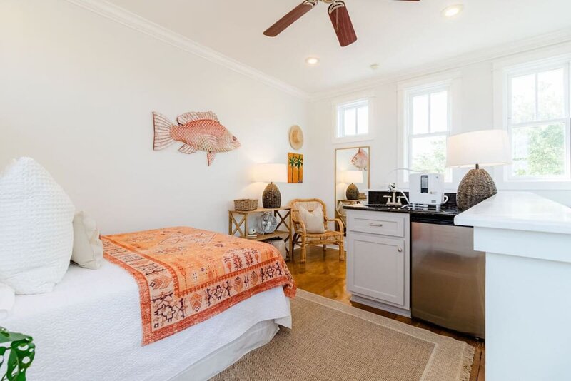 bedroom with queen bed sink and refrigerator