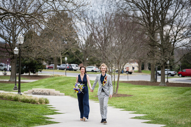 A couple walks hand-in-hand on Virginia Tech's campus on their elopement day.