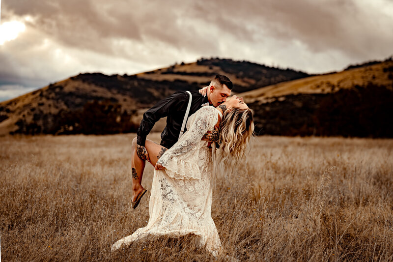 Family Photographer, a couple embraces in a dry grassy field