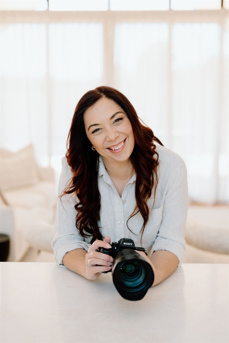 A photo of Tashina Narelle showing the back of a camera to the bride and groom. Auckland wedding photographer and videographer
