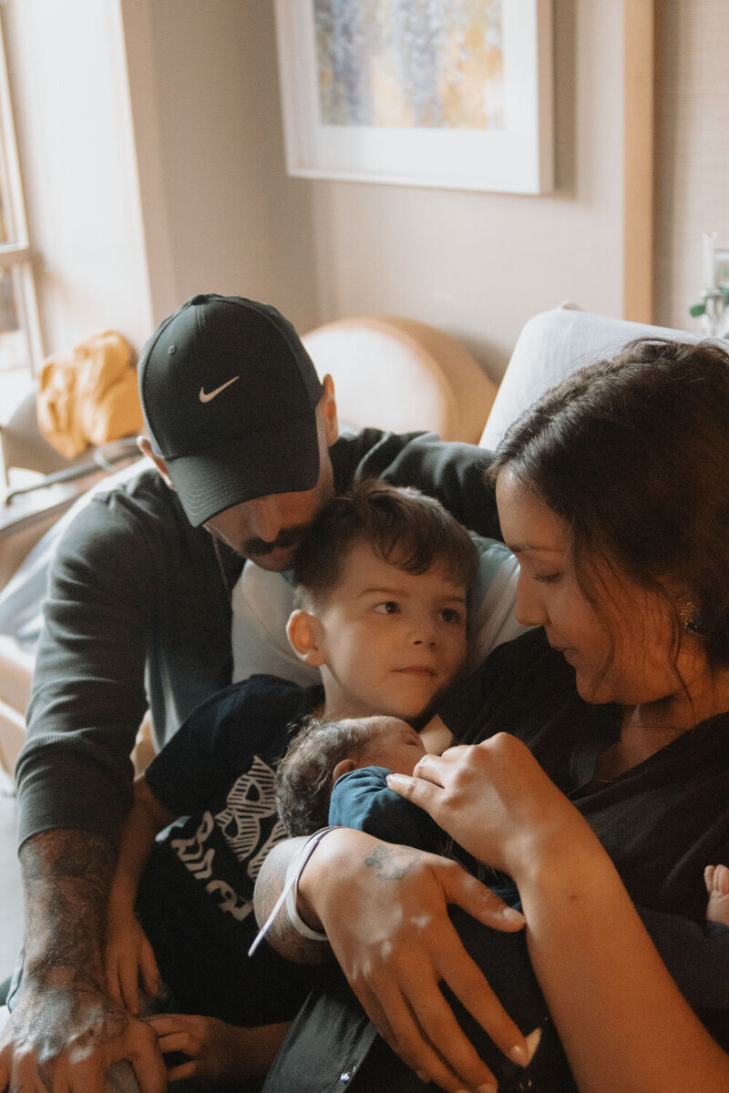 amily snuggling with their newborn baby, creating a loving moment