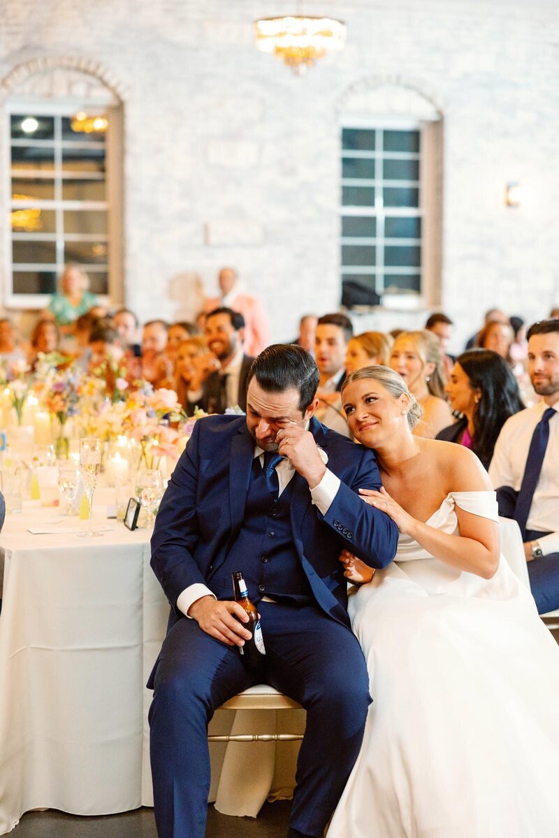 bride and groom are emotional while listening to their loves ones heartwarming speech at Grbic Events, a wedding venue in St. Louis.