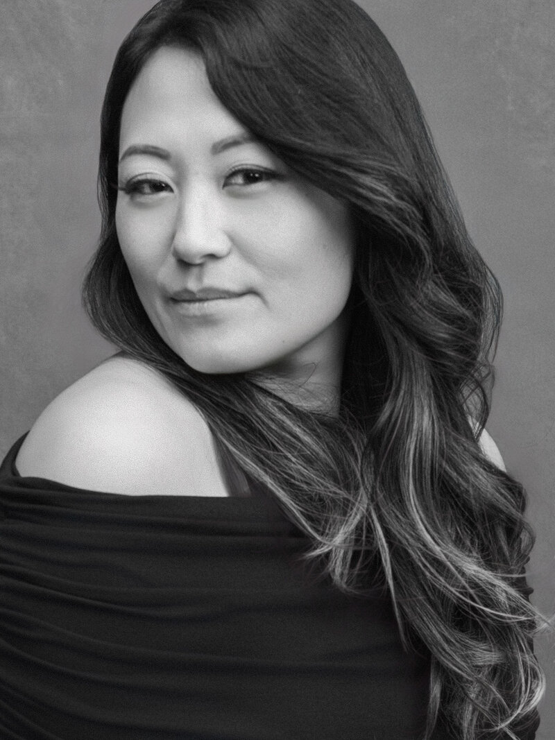 black and white image of elle yeon black dress and soft smirk
