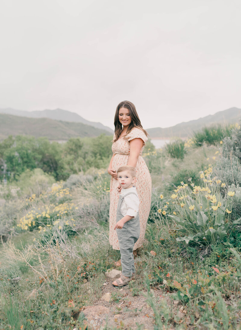 Peaceful mountain view with mom-to-be in neutral-toned dress. CAPTURED BY Newborn Photography Salt Lake City, Newborn Photographer Riverton, Maternity Photographer Salt Lake City.