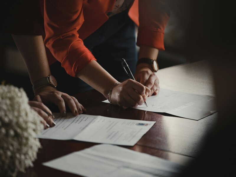 Women signing documents with pen