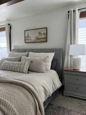 Calming bedroom design with layered linen bedding and warm lighting.