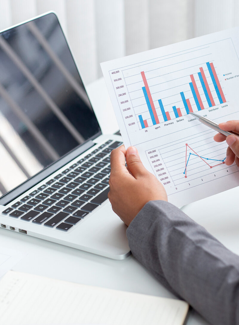 A Dallas financial consulting expert is analyzing personalized financial growth. He is holding a document with statistics and has a professional laptop in front of him, demonstrating a detailed review of financial data for sustainable business growth.